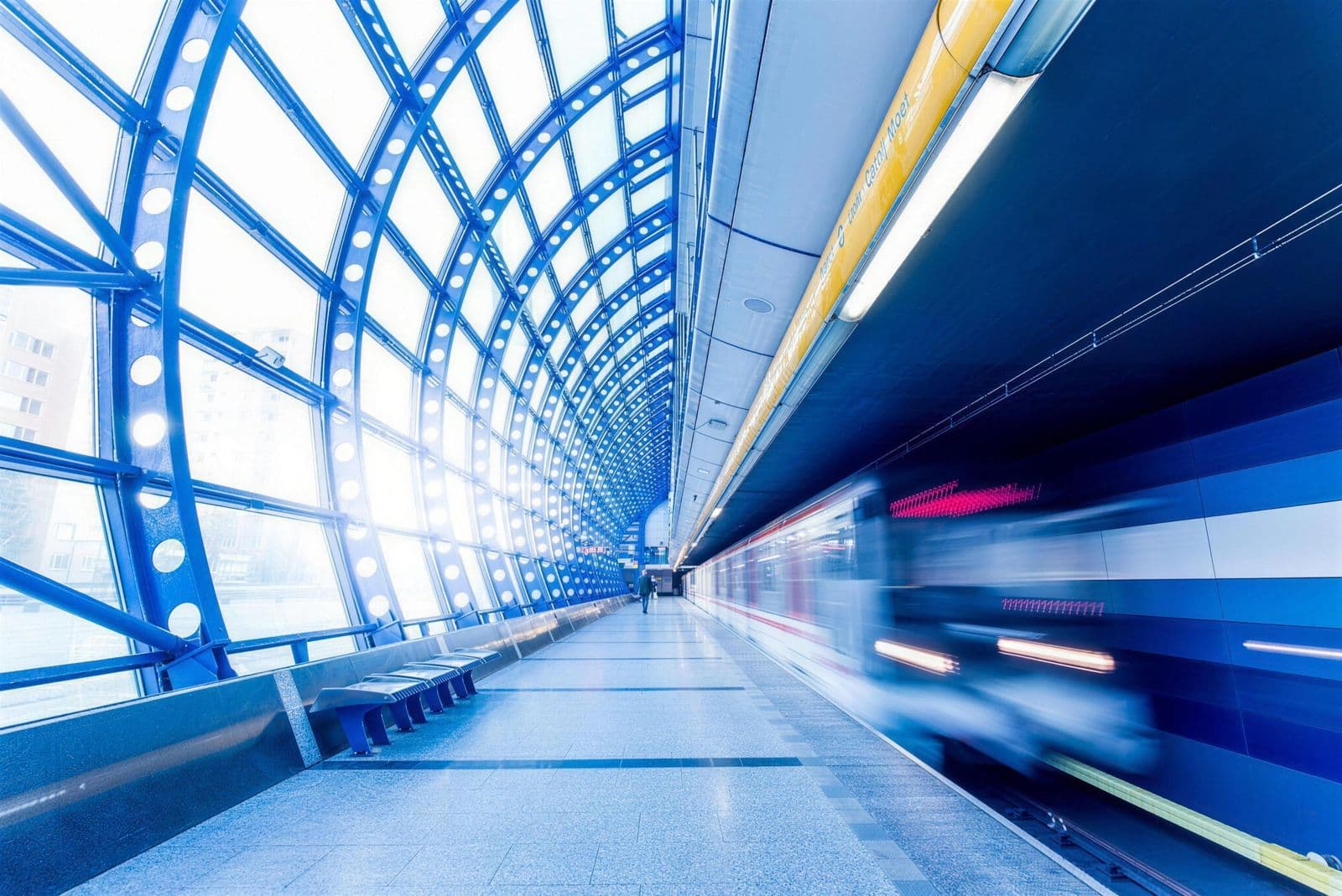 Train arriving at a glass-roofed station platform